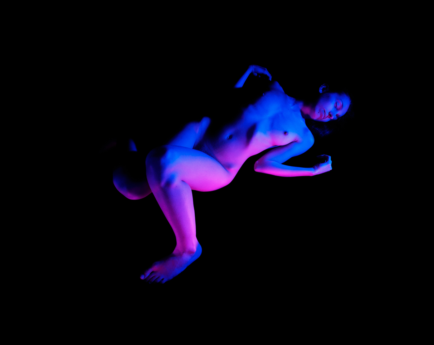 Woman lying with blue and pink lights.